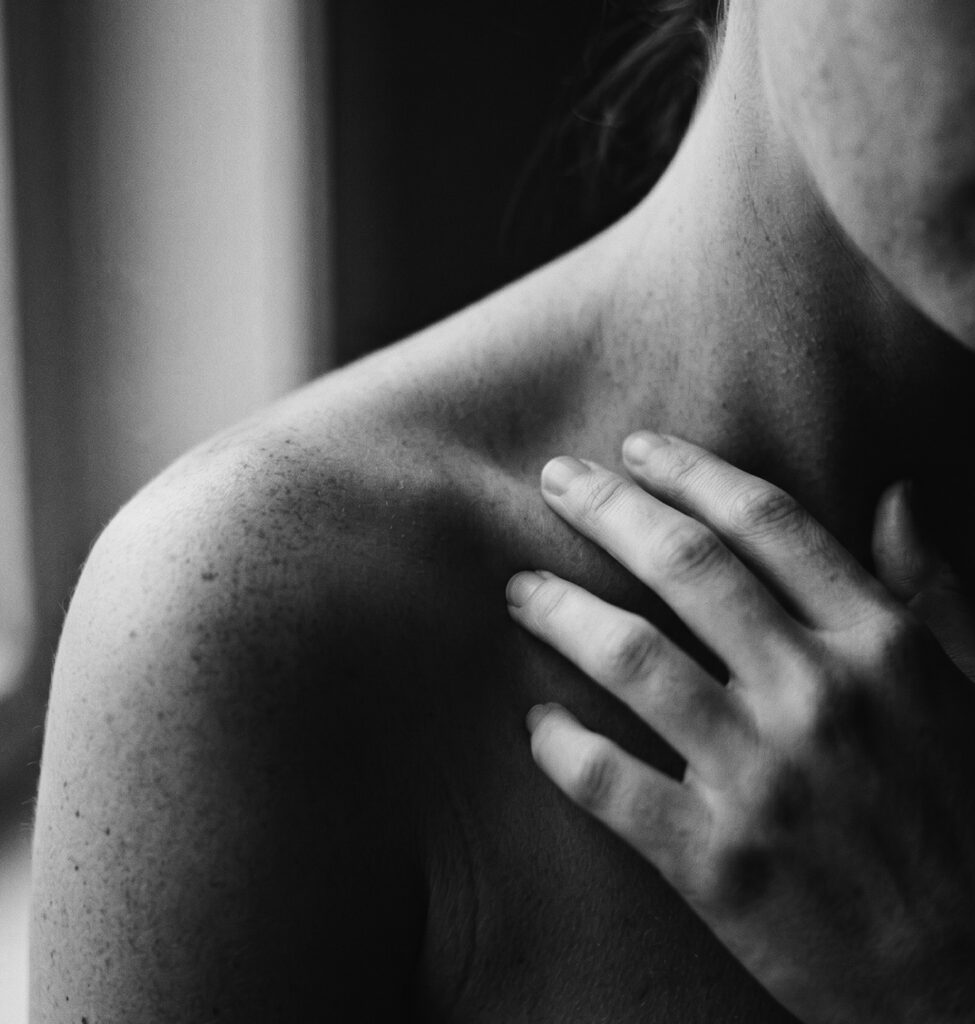 Mano de mujer apoyada sobre el hombro y la clavícula