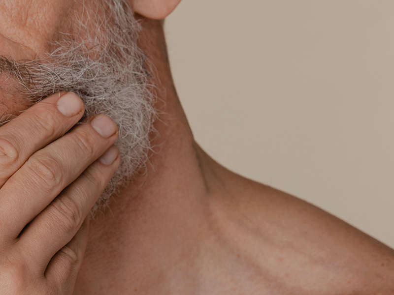 Mano de la fisioterapeuta sobre el cuello de un hombre mayor